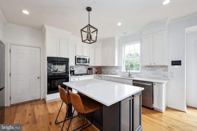 5915 Copper Mountain Dr W, Spotsylvania, VA 22553 - kitchen featuring stainless steel appliances, crown molding, light wood-type flooring, backsplash, and white cabinetry