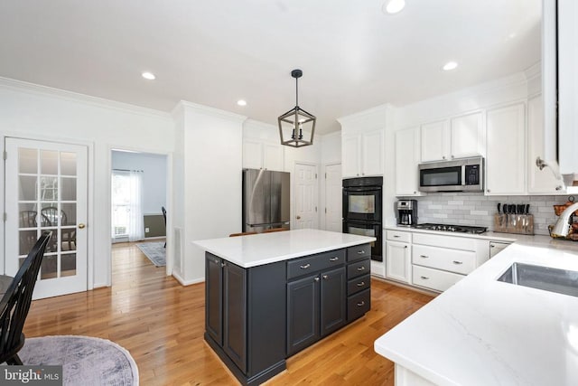 5915 Copper Mountain Dr W, Spotsylvania, VA 22553 - kitchen with stainless steel appliances, white cabinetry, a kitchen island, tasteful backsplash, and ornamental molding