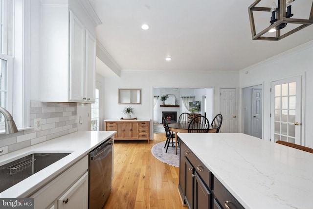 5915 Copper Mountain Dr W, Spotsylvania, VA 22553 - kitchen with stainless steel dishwasher, crown molding, a warm lit fireplace, white cabinetry, and tasteful backsplash