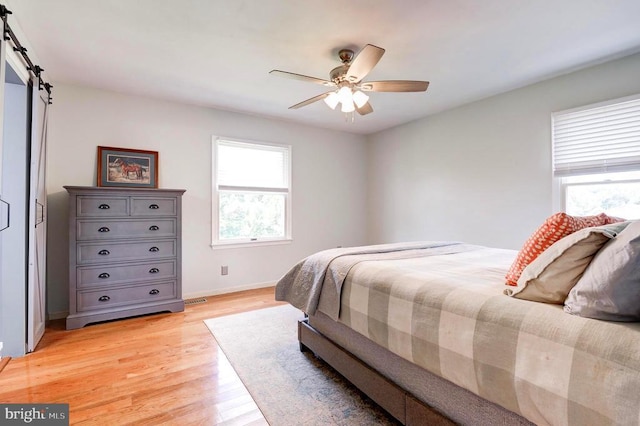 18691 Springs Rd, Jeffersonton, VA 22724 - bedroom featuring light wood finished floors, a ceiling fan, and a barn door