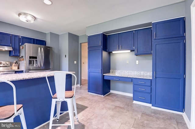 18691 Springs Rd, Jeffersonton, VA 22724 - kitchen featuring appliances with stainless steel finishes, under cabinet range hood, built in desk, blue cabinets, and a kitchen breakfast bar