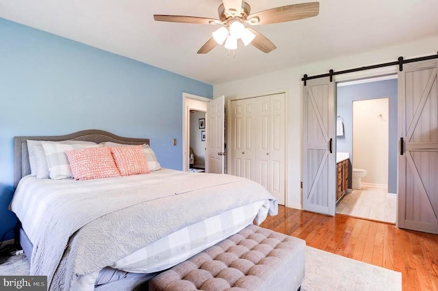 18691 Springs Rd, Jeffersonton, VA 22724 - bedroom featuring a barn door, a closet, light wood-style floors, and a ceiling fan