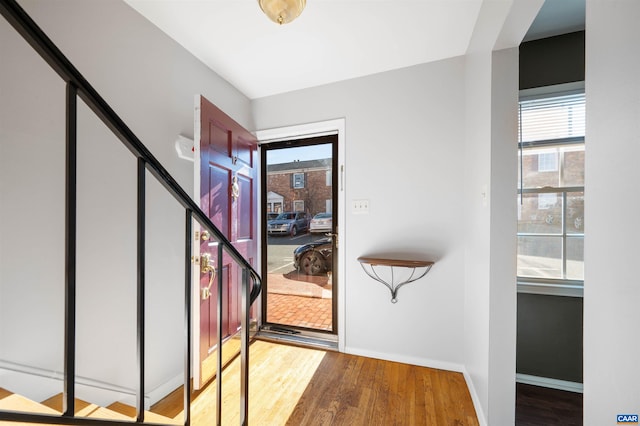 entrance foyer featuring baseboards, a wealth of natural light, and wood finished floors