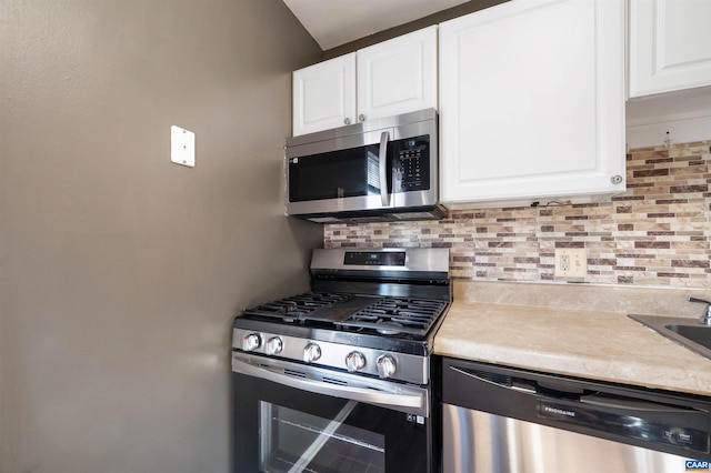 kitchen with tasteful backsplash, light countertops, white cabinets, and appliances with stainless steel finishes