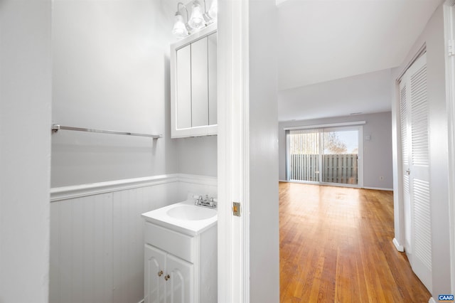 bathroom featuring a wainscoted wall, wood finished floors, and vanity