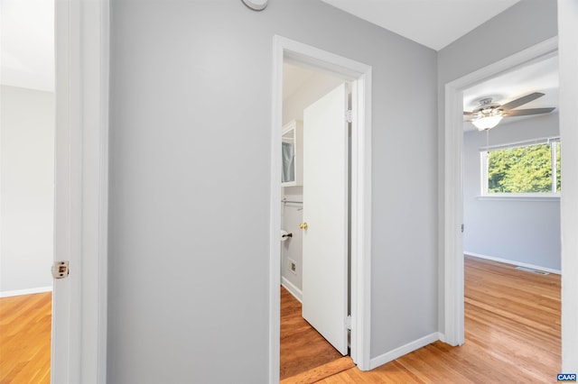 hall with light wood-type flooring and baseboards