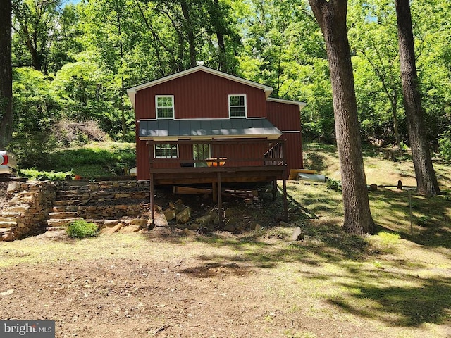  - rustic home with a wooden deck, a standing seam roof, and a forest view