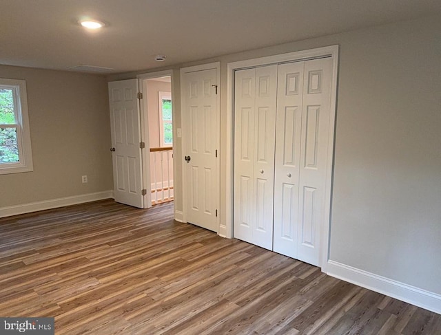  - unfurnished bedroom featuring wood finished floors and a closet