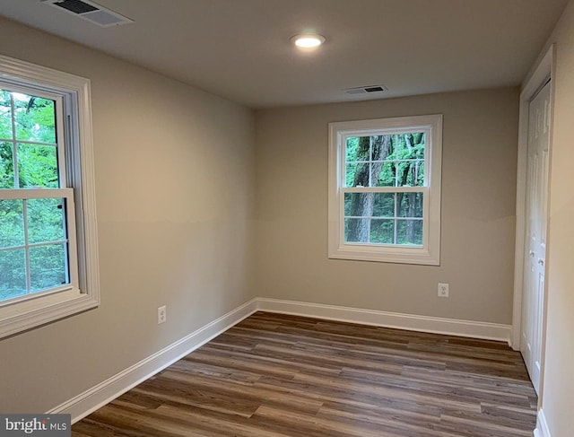  - unfurnished bedroom featuring multiple windows, dark wood-style floors, and recessed lighting