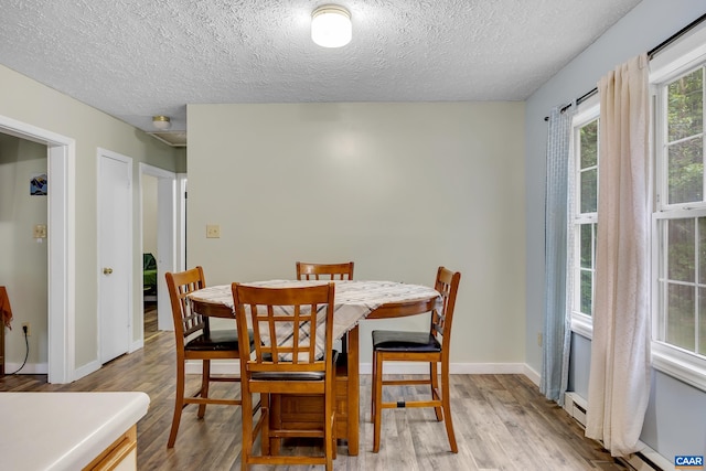 1409 Mica Rd, Mineral, VA 23117 - dining area featuring wood finished floors, a textured ceiling, and a baseboard heating unit