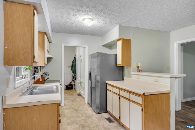 1409 Mica Rd, Mineral, VA 23117 - kitchen with a peninsula, light countertops, a textured ceiling, stainless steel fridge, and range
