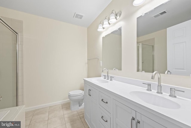 bathroom featuring a shower with door, tile patterned flooring, baseboards, double vanity, and toilet
