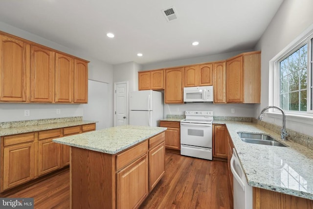 kitchen with white appliances, a sink, dark wood-type flooring, recessed lighting, and light stone countertops