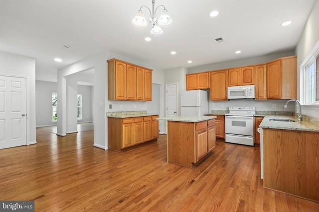 kitchen featuring white appliances, a sink, healthy amount of natural light, wood finished floors, and recessed lighting