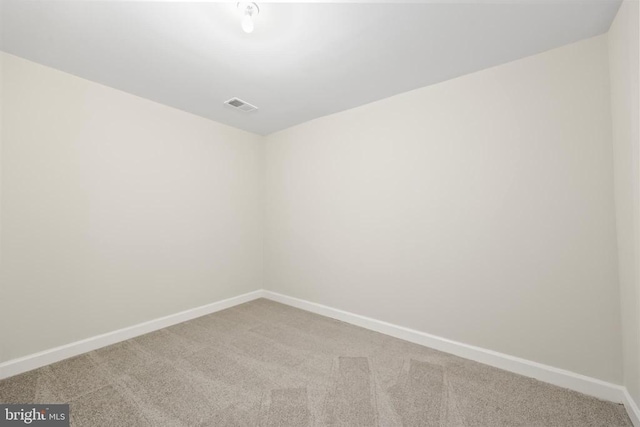 carpeted empty room featuring baseboards