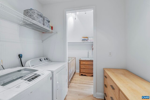 laundry area featuring separate washer and dryer and light wood-style flooring