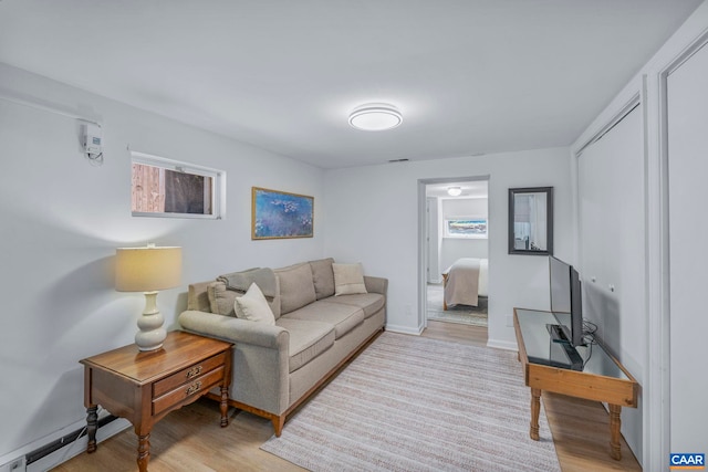living area featuring light wood finished floors and baseboard heating