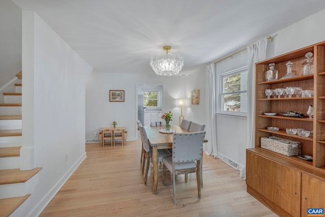 dining area with stairway, light wood finished floors, and plenty of natural light