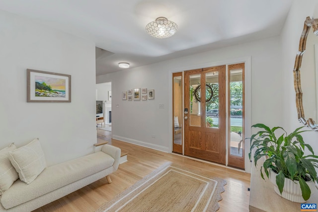 foyer entrance with baseboards and light wood-style flooring