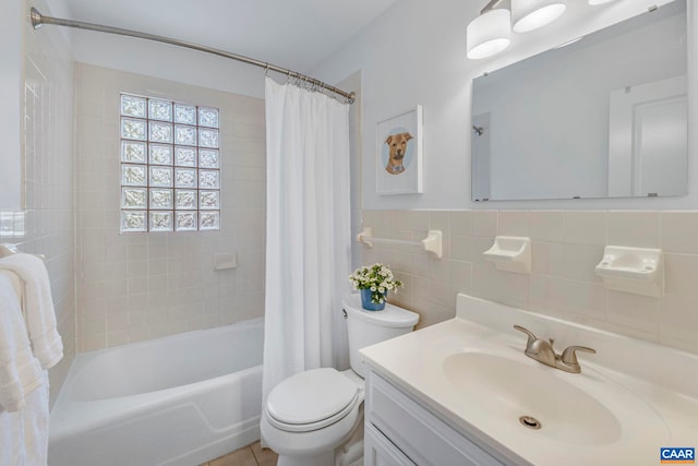 bathroom with toilet, shower / bath combo, vanity, and tile walls