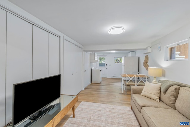 living area with healthy amount of natural light and light wood-style floors