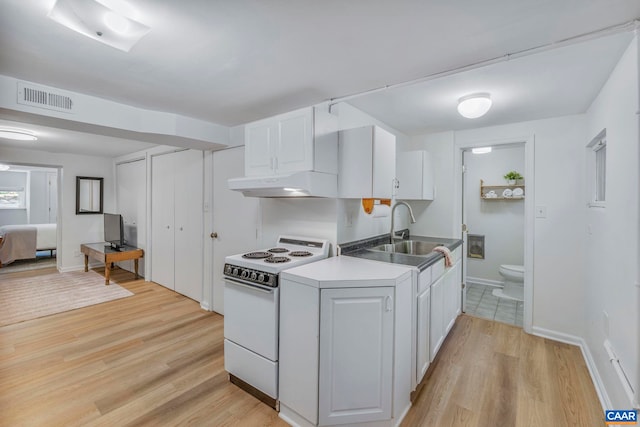 kitchen featuring white range with electric cooktop, under cabinet range hood, a sink, light wood-style floors, and white cabinets