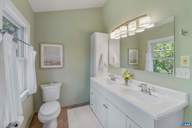 bathroom featuring plenty of natural light, baseboards, tile patterned flooring, and double vanity