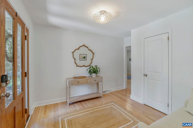 foyer with light wood-style flooring and baseboards