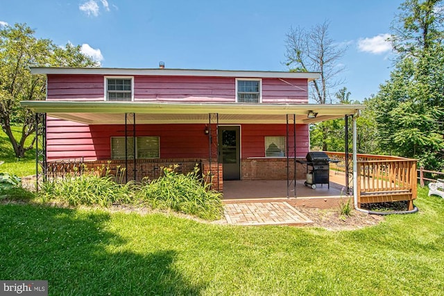  - back of property with a yard, brick siding, and covered porch