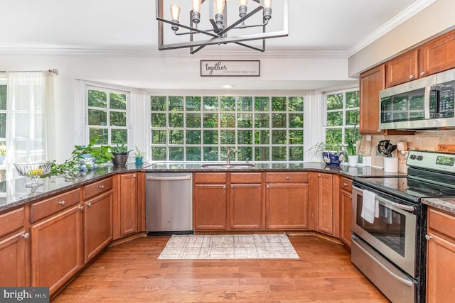 9603 Conaty Cir, Spotsylvania, VA 22553 - kitchen with appliances with stainless steel finishes, crown molding, plenty of natural light, a chandelier, and brown cabinets