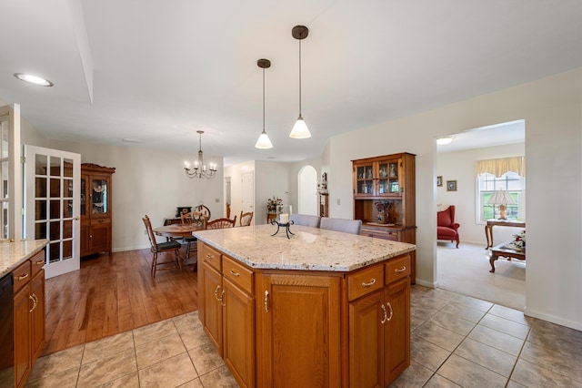 5409 Smith Creek Rd, New Market, VA 22844 - kitchen with arched walkways, brown cabinetry, a kitchen island, light tile patterned floors, and hanging light fixtures