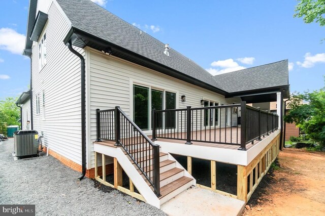 rear view of property featuring cooling unit, a shingled roof, and a deck