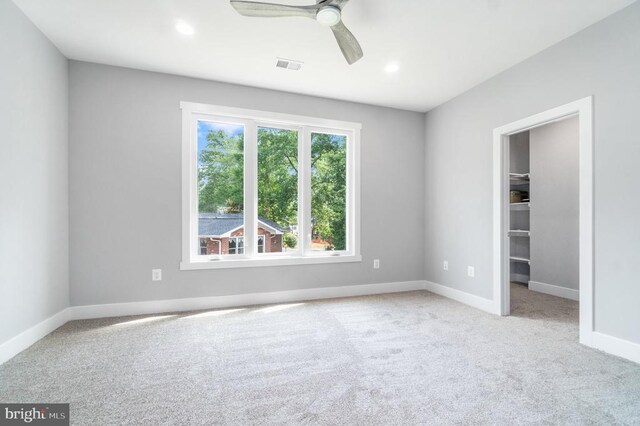 unfurnished bedroom with carpet floors, baseboards, a spacious closet, ceiling fan, and recessed lighting