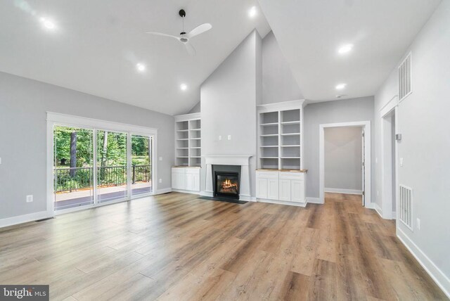 unfurnished living room with a ceiling fan, baseboards, high vaulted ceiling, built in features, and light wood-type flooring