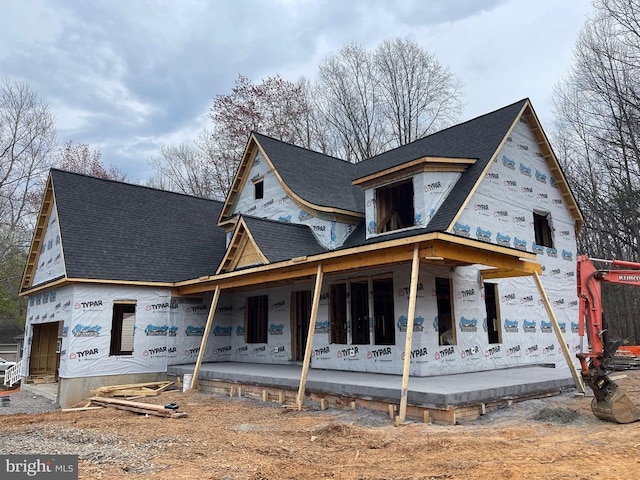 property in mid-construction with covered porch and roof with shingles
