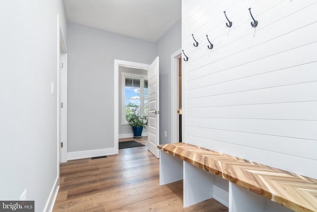 mudroom with wood finished floors and baseboards