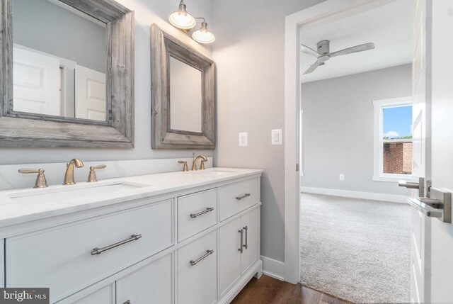 full bath with double vanity, baseboards, and ceiling fan
