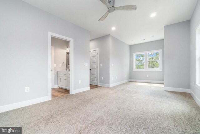 unfurnished bedroom featuring carpet, baseboards, recessed lighting, ensuite bathroom, and a ceiling fan