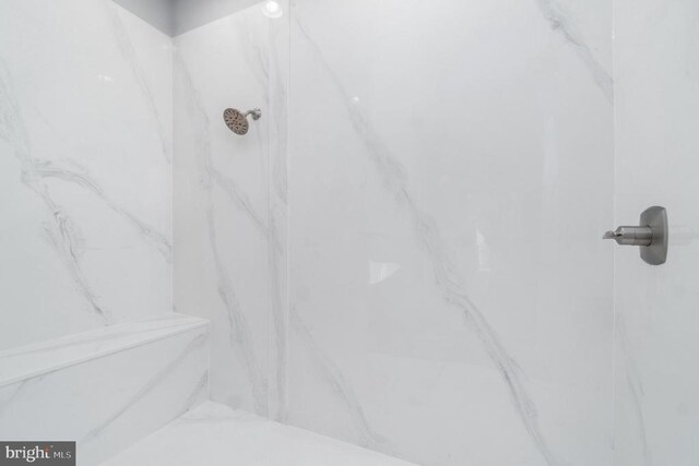 bathroom view of a marble finish shower