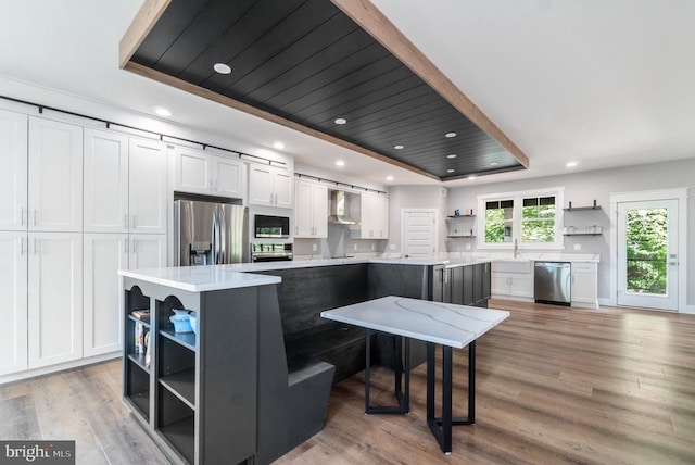 3200 Lakeview Pkwy, Locust Grove, VA 22508 - kitchen featuring open shelves, stainless steel appliances, white cabinetry, a tray ceiling, and wall chimney range hood