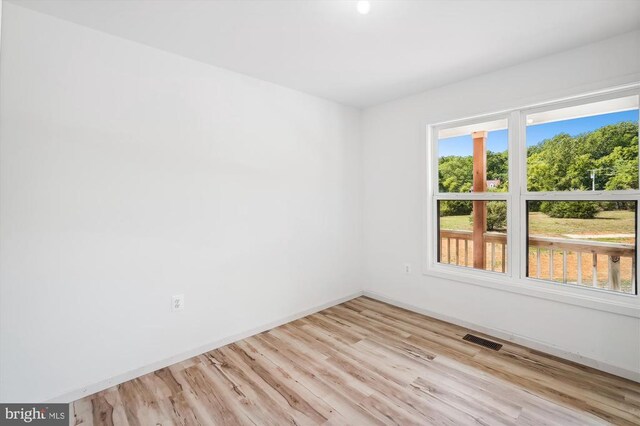 unfurnished room with wood finished floors and baseboards