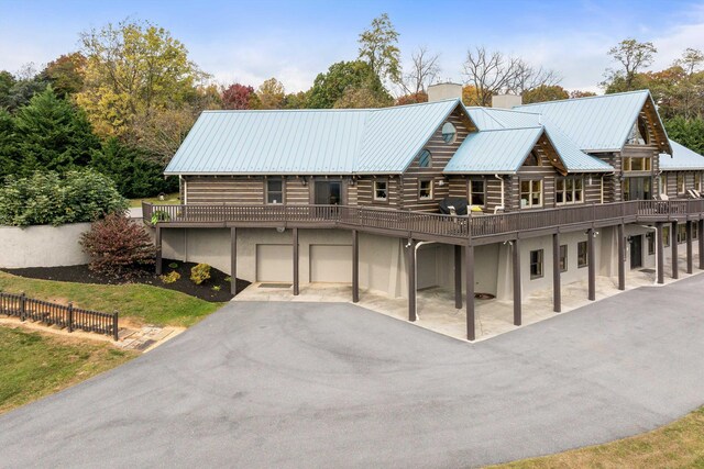 928 Melrose Rd, Rockingham, VA 22802 - view of front of property featuring a garage, stucco siding, a chimney, driveway, and log exterior