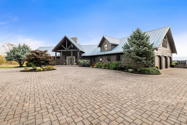 928 Melrose Rd, Rockingham, VA 22802 - view of front of home with curved driveway, a garage, metal roof, and a chimney
