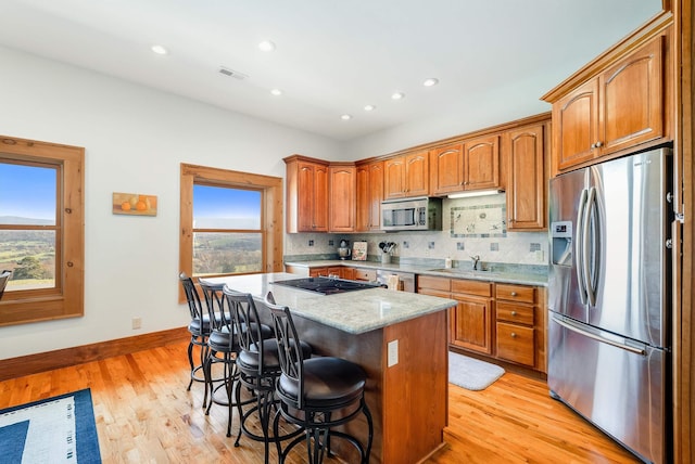 928 Melrose Rd, Rockingham, VA 22802 - kitchen featuring a sink, stainless steel appliances, tasteful backsplash, light wood finished floors, and a kitchen island