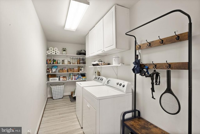 laundry area with cabinet space, washer and clothes dryer, light wood finished floors, and baseboards