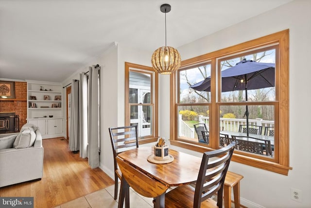 dining space with baseboards, a chandelier, and built in shelves