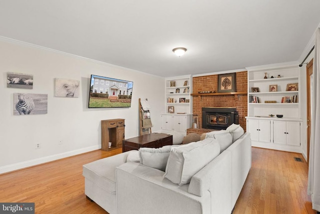 living room featuring light wood finished floors, baseboards, crown molding, a fireplace, and built in shelves