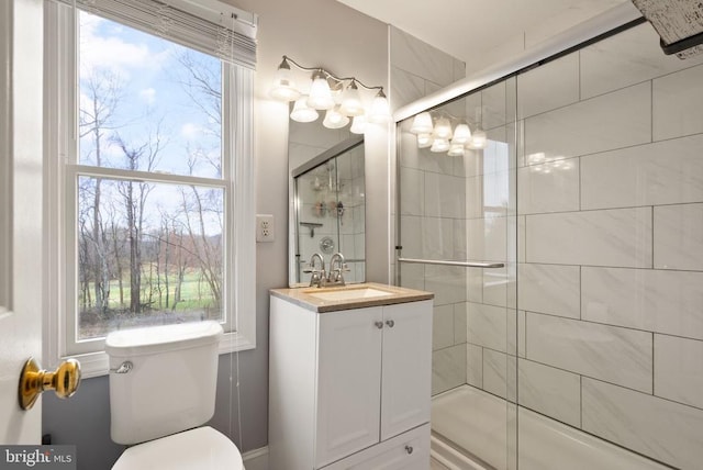 full bath featuring a stall shower, vanity, and toilet