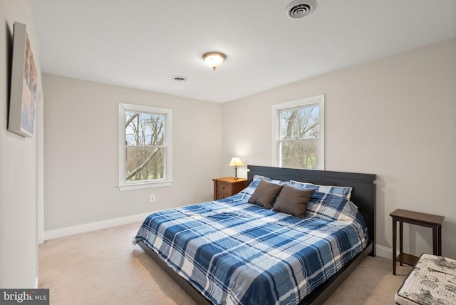carpeted bedroom featuring baseboards and multiple windows