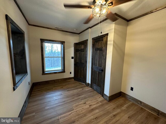 152 Susan Ln, Stanley, VA 22851 - unfurnished bedroom with crown molding, baseboards, wood finished floors, and a ceiling fan